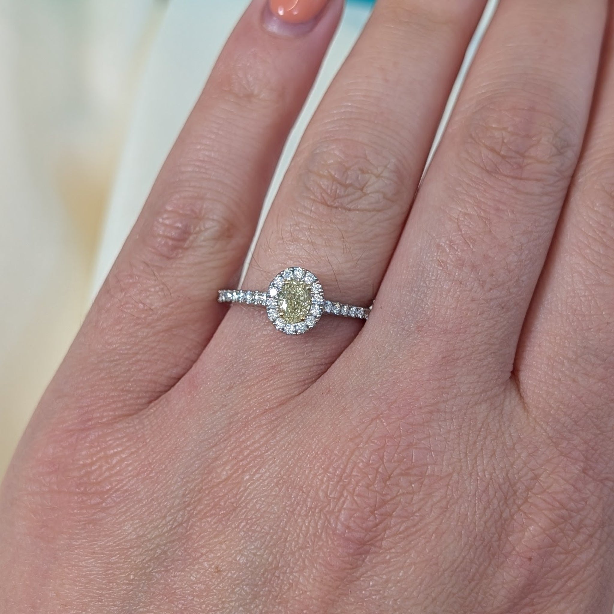 Oval yellow diamond and diamond halo cluster ring in platinum and 18ct gold