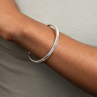 Mill grain edge bangle in silver.