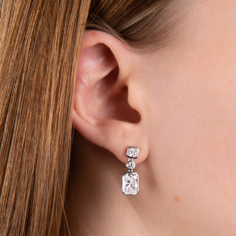 Cubic zirconia three stone drop earrings in silver.