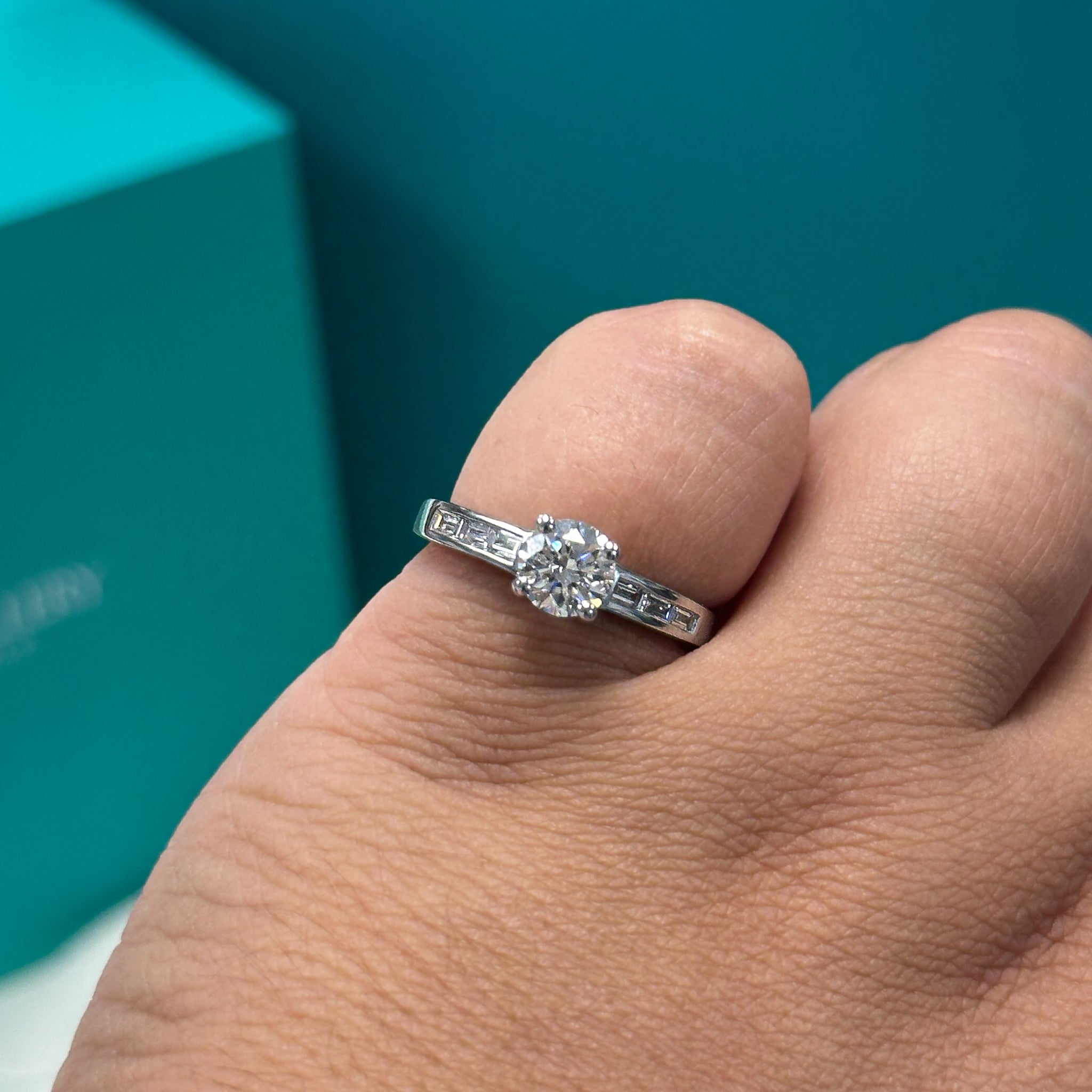 Diamond solitaire ring with baguette diamond set shoulders in platinum, 0.89ct