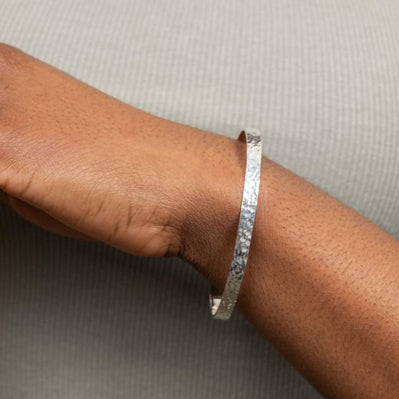 Hammered detail bangle in silver.