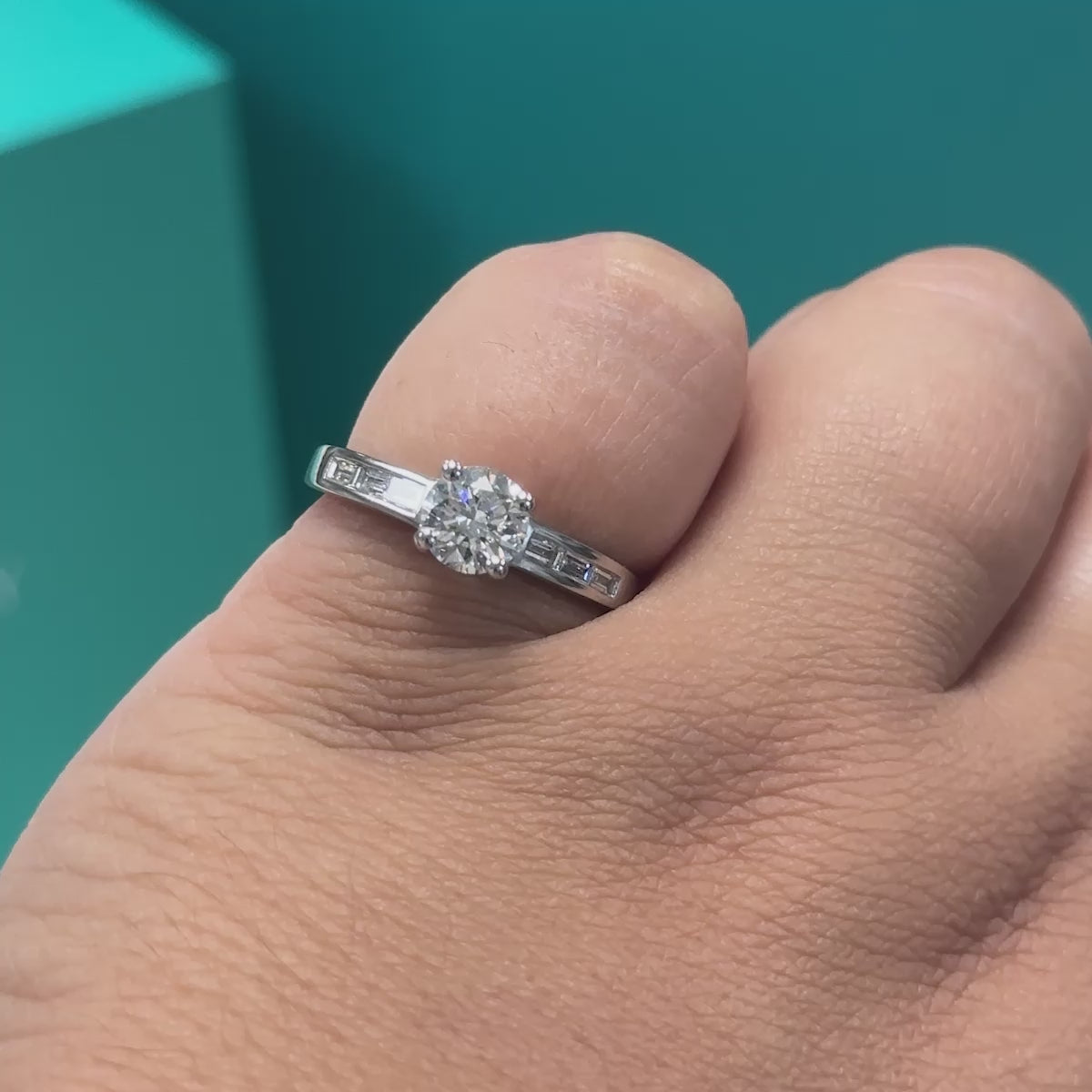 Diamond solitaire ring with baguette diamond set shoulders in platinum, 0.89ct